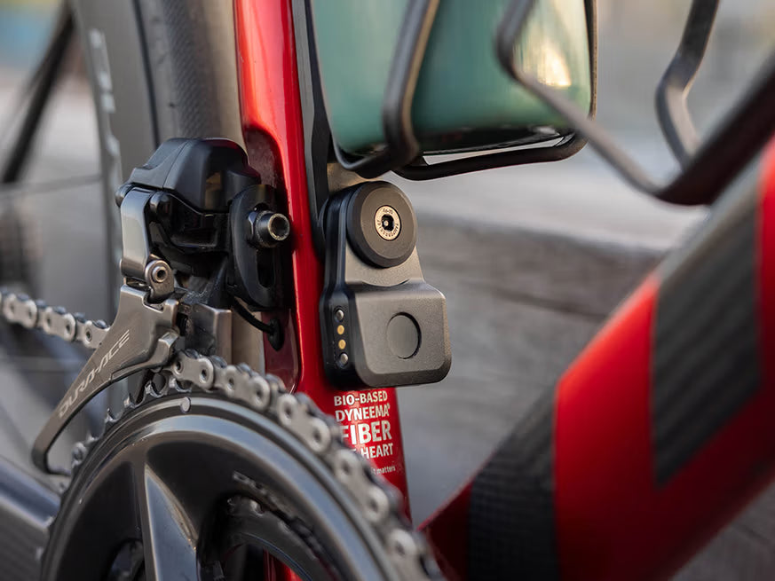 QUAD LOCK Bike Alarm and Finder - op een rood fietsframe onder een bidonhouder